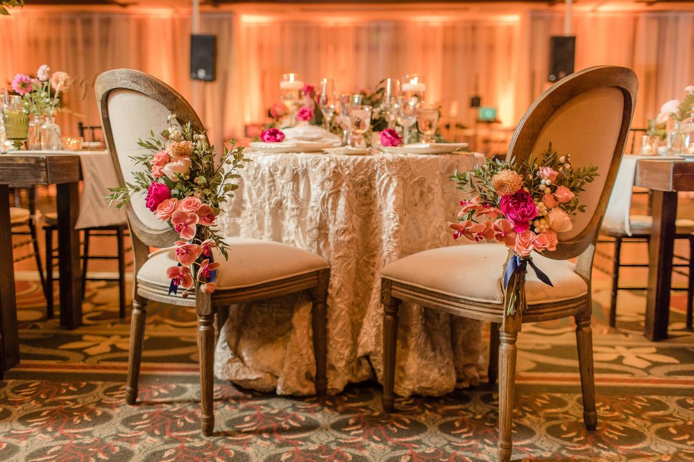 Peach uplighting and ceiling draping behind the sweetheart table at The Lodge at Torrey Pines wedding