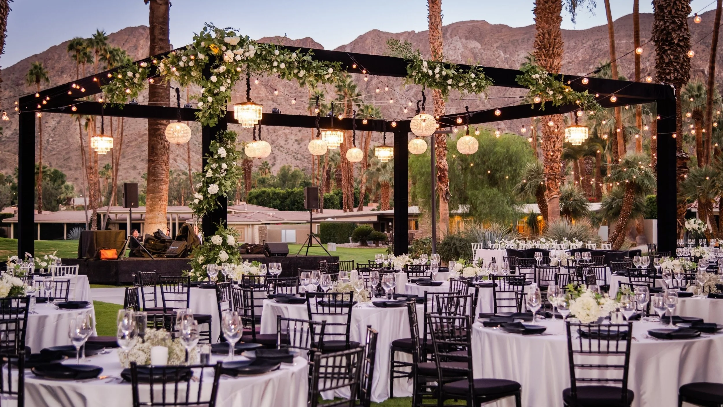Outdoor truss pergola with chandeliers and market lights at luxury reception