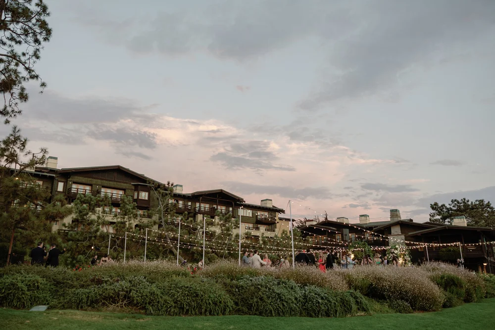 Cafe lights illuminating the exterior of The Lodge at Torrey Pines at sunset on a wedding evening