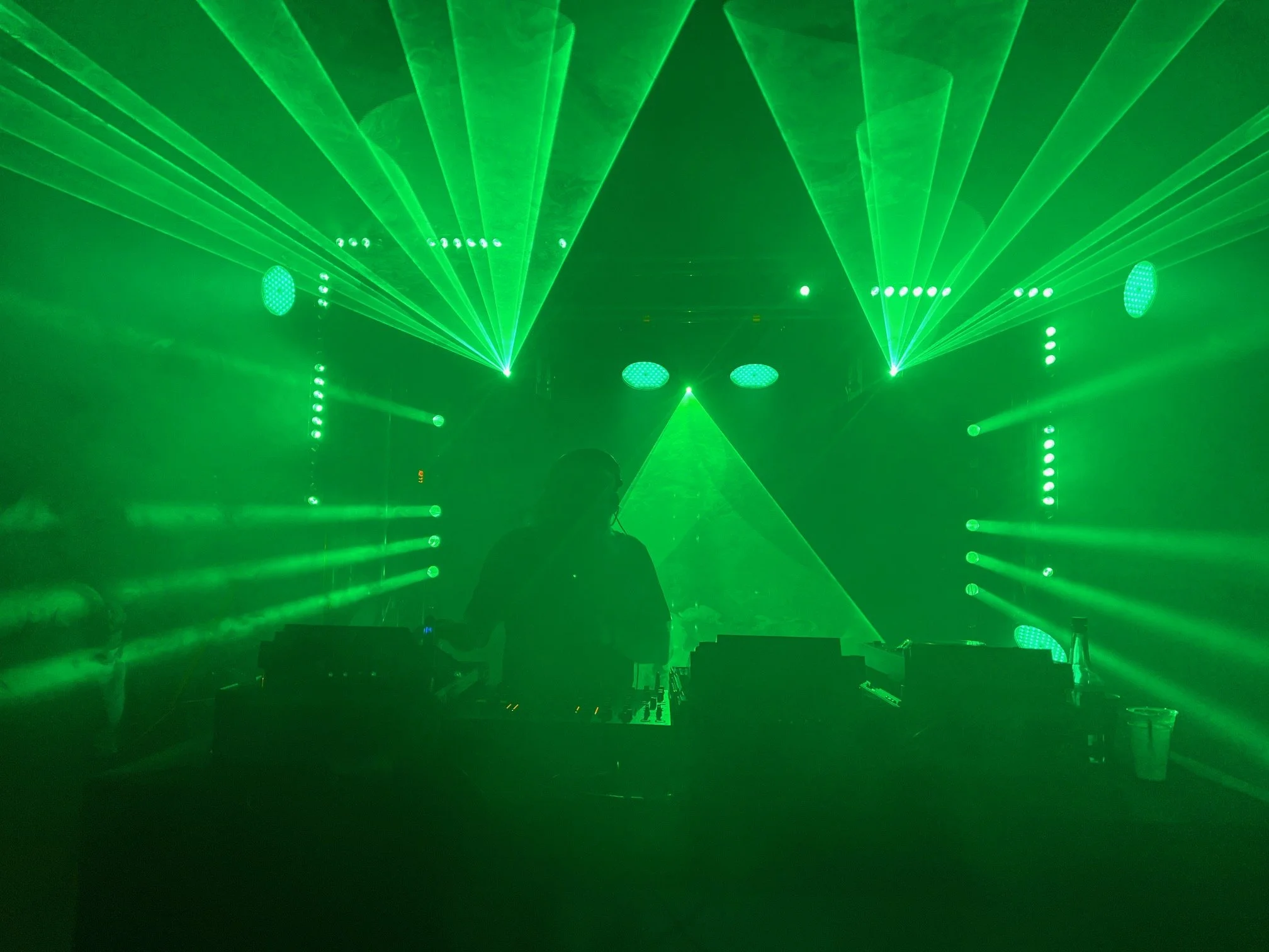 Vibrant laser beams creating dynamic patterns above a dance floor at a high-energy event