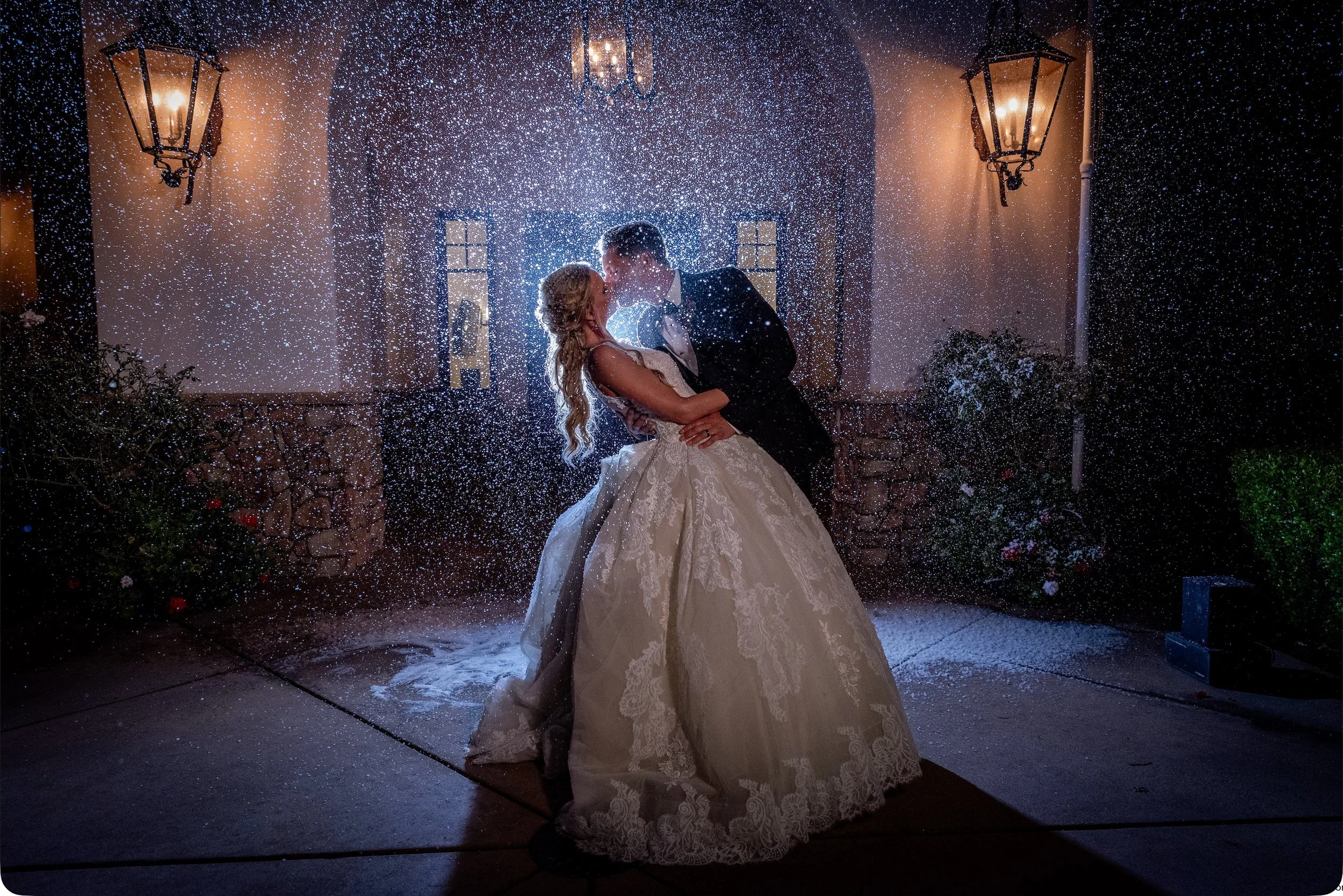 Artificial snow falling over guests at an outdoor holiday-themed event