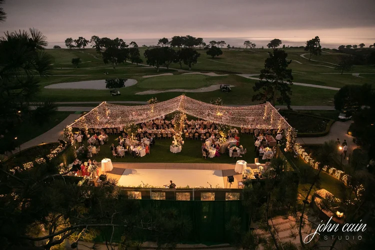 Aerial drone view of a twinkle-light canopy over a wedding reception at The Lodge at Torrey Pines