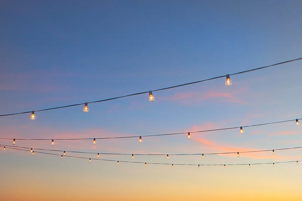 Farm tables under market lights at blue hour