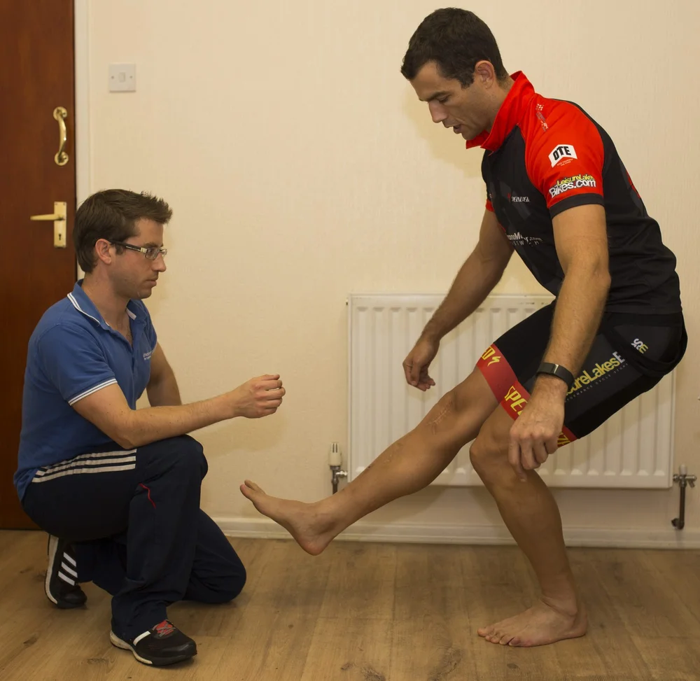 An HP3 physiotherapist watching a cyclist perform a single-leg squat during the movement screen before the fit
