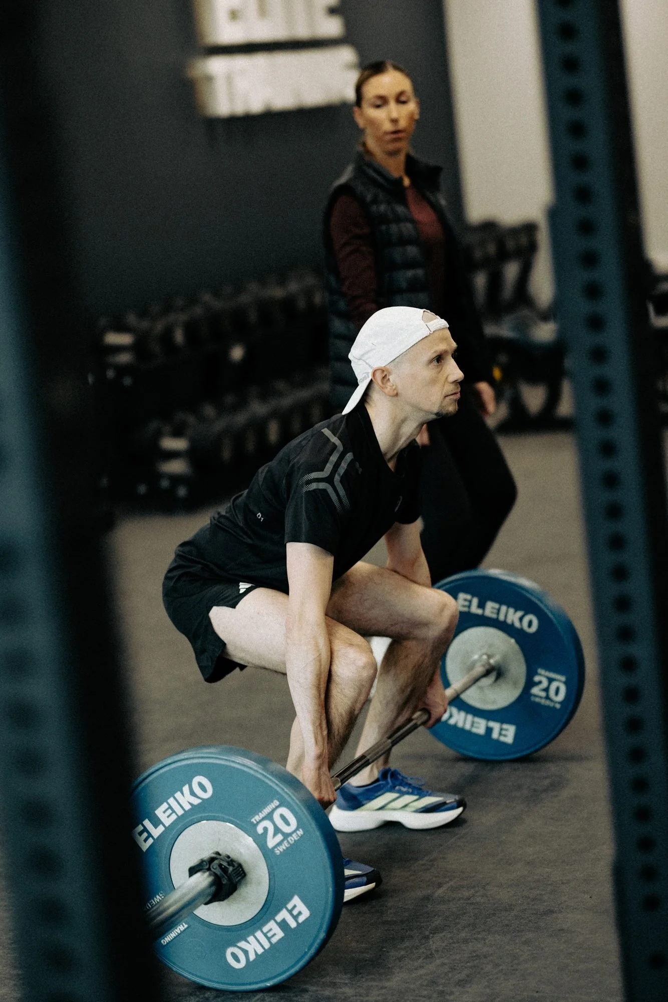 HP3's strength and conditioning coach watching an athlete set up a barbell deadlift in the gym