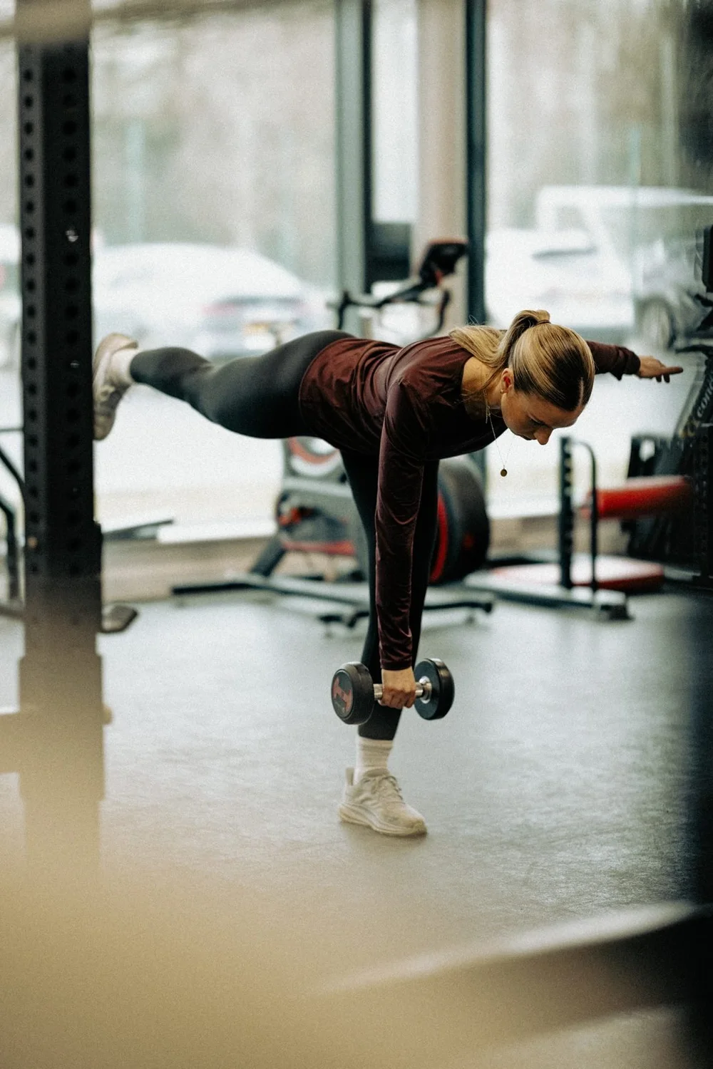 An athlete balancing in a single-leg Romanian deadlift with a dumbbell