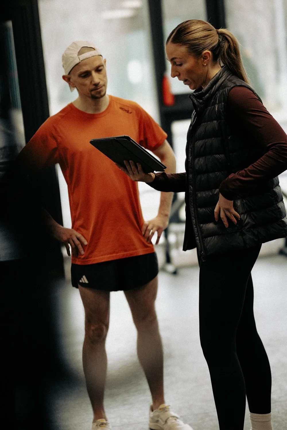 An HP3 physiotherapist and a runner going through his history together on a tablet