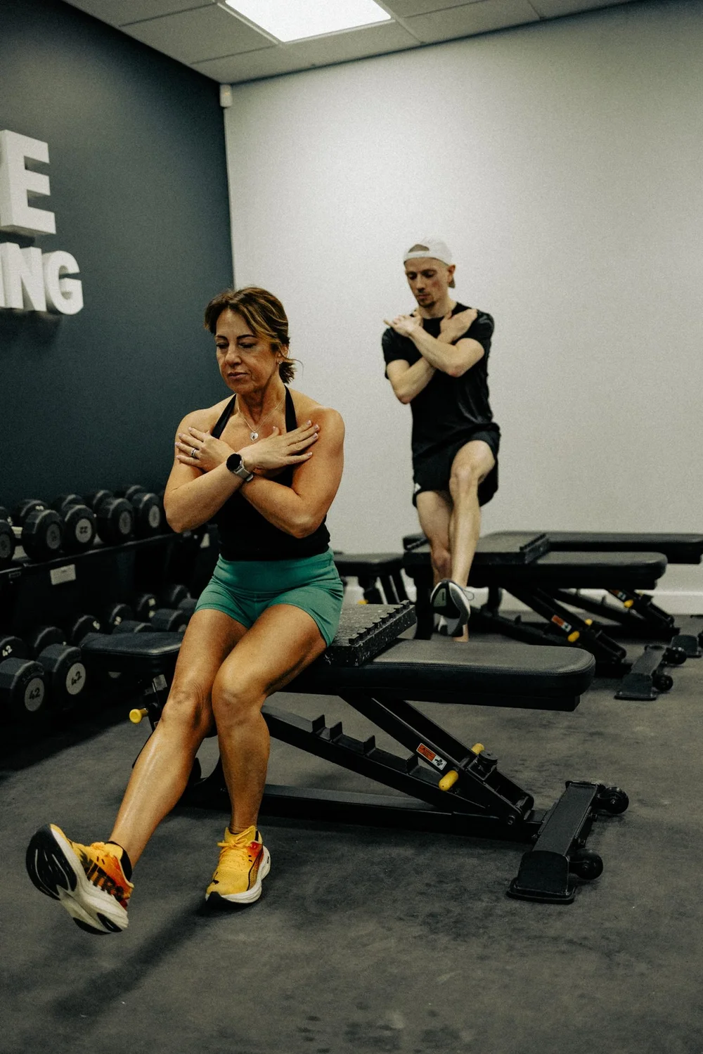 Two athletes doing seated trunk exercises on benches in the HP3 gym
