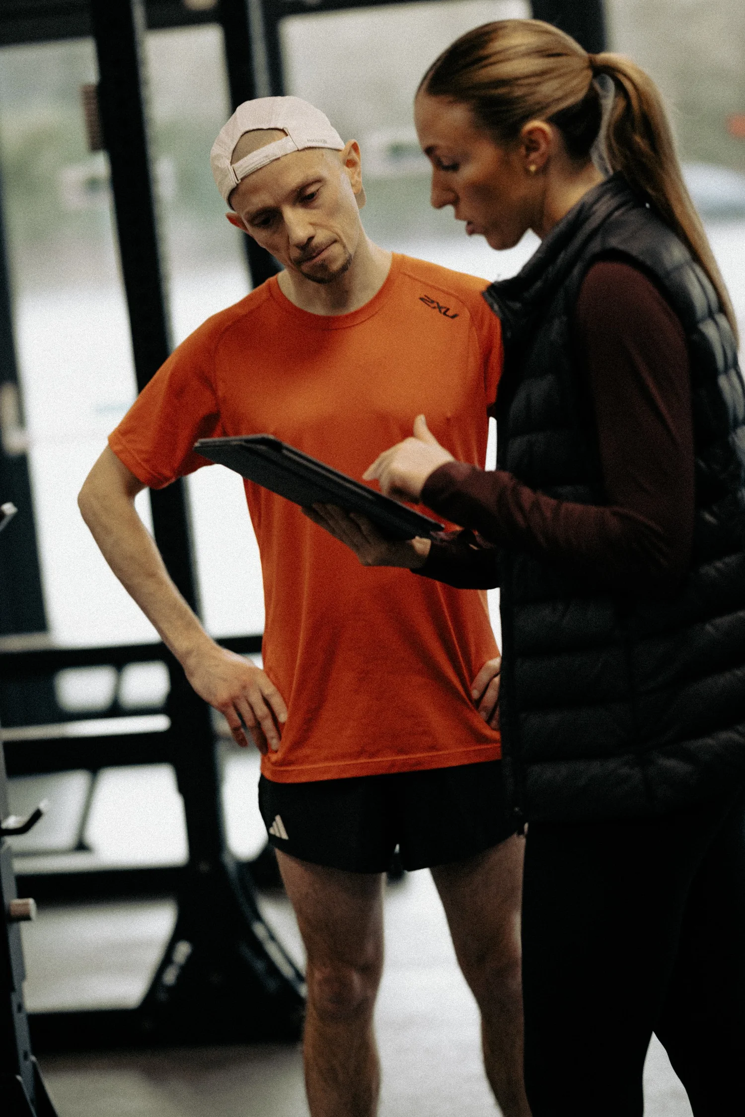 HP3 coach talking an athlete through their assessment results on a tablet in the gym