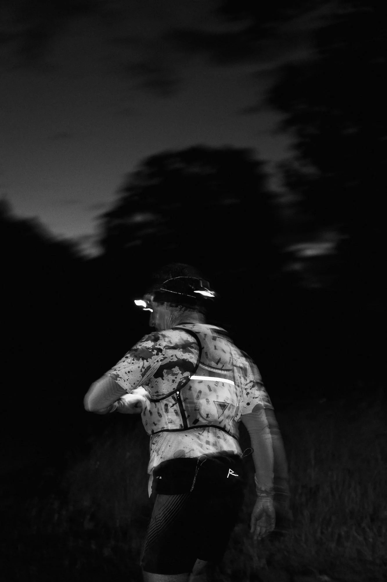 An HP3 athlete running by head torch at dusk on the West Highland Way