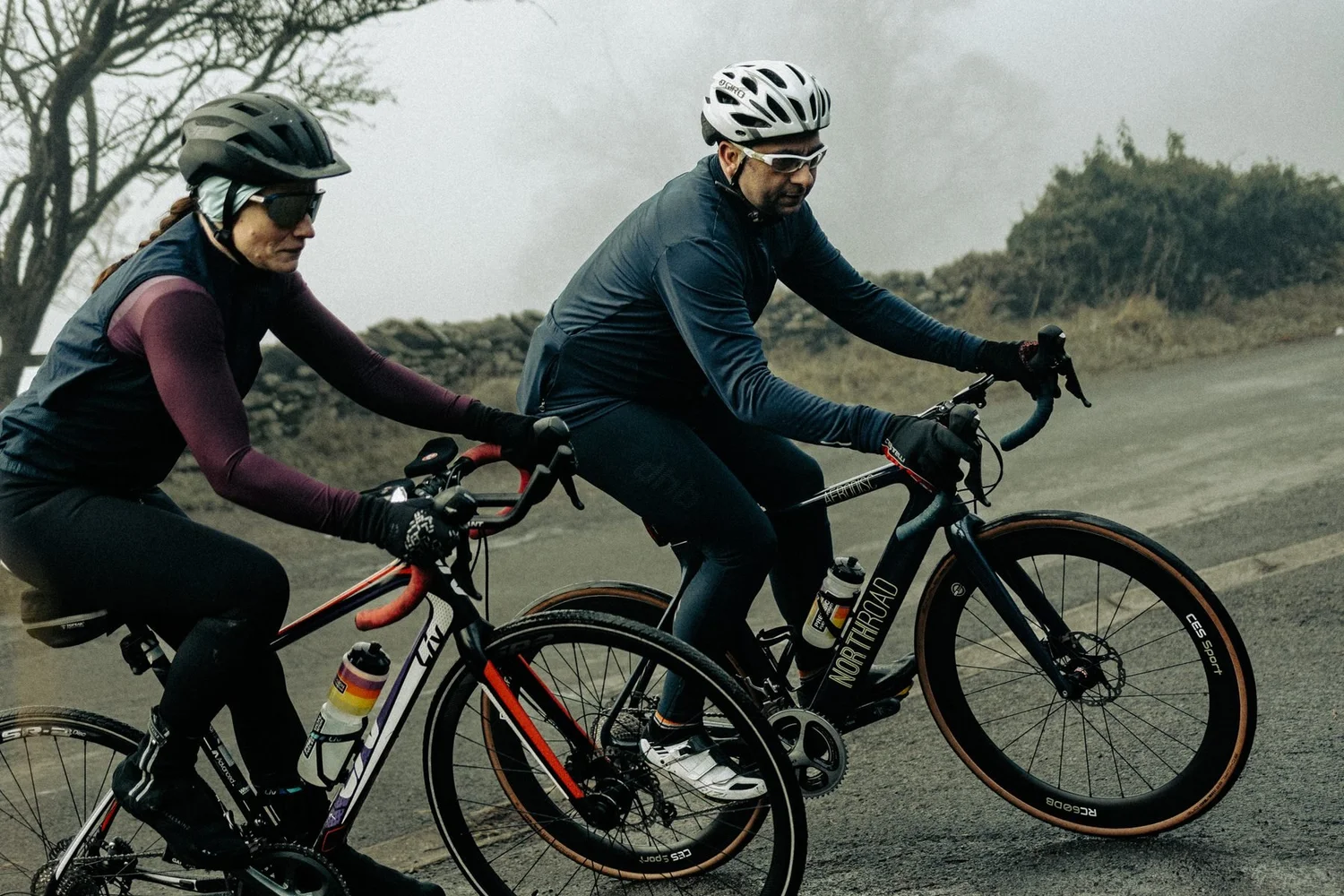 Dr Liz Mahon and Dr Howard Hurst, HP3 sports nutritionists, riding road bikes together up a misty lane