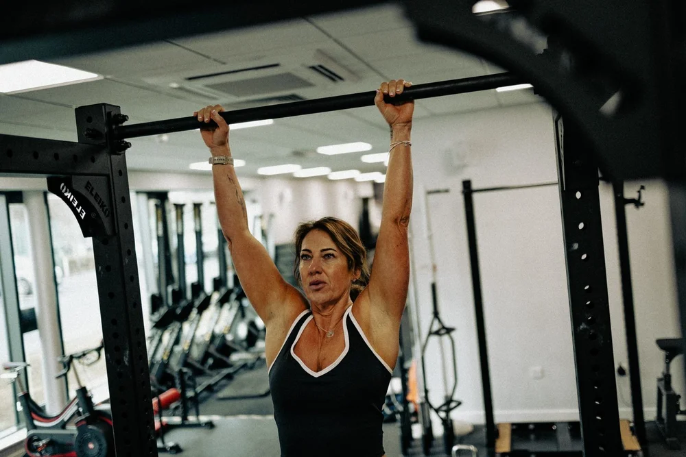 An athlete at the top of a barbell overhead press in the gym