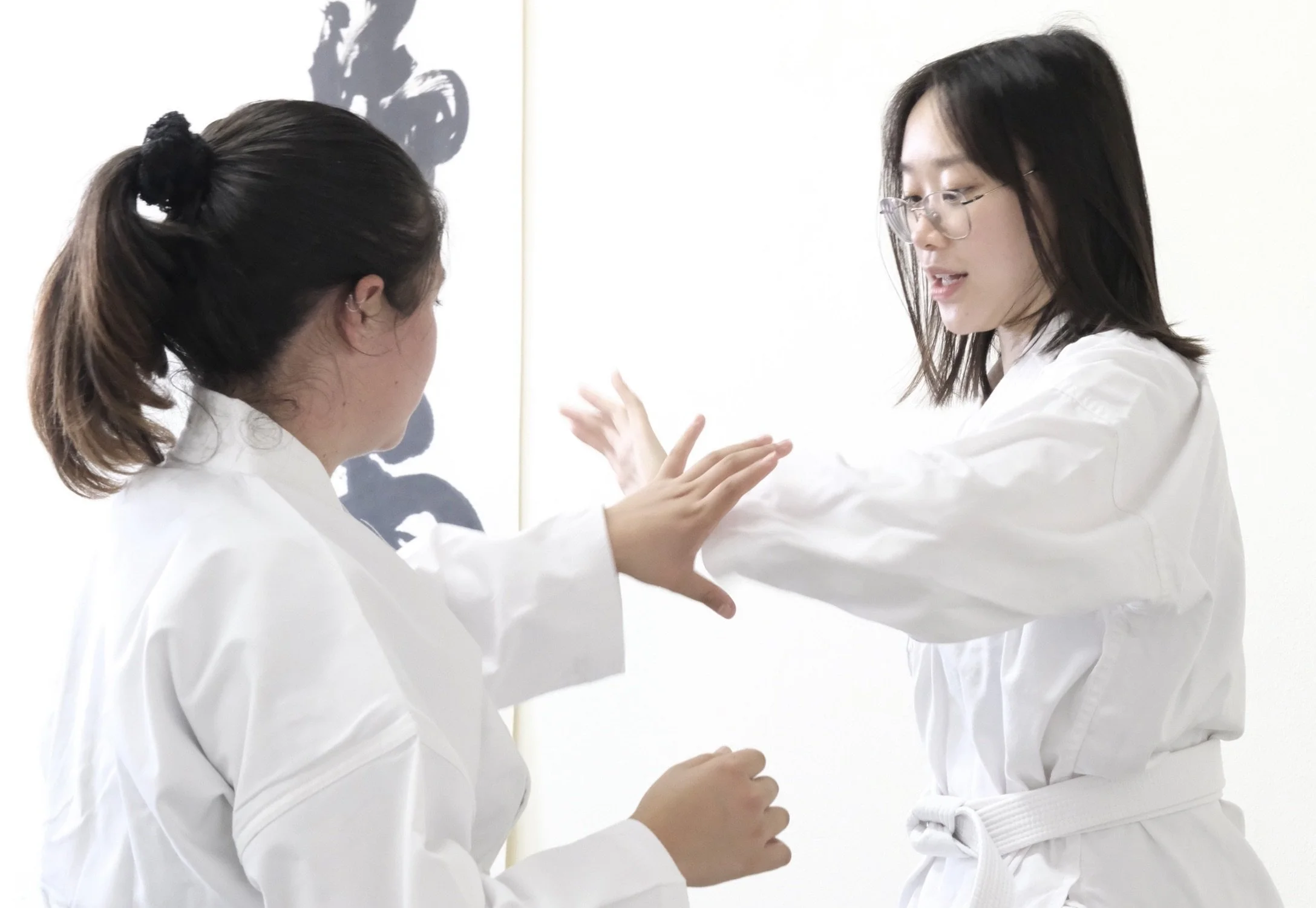 Two Budo Scholar students practicing a technique in an aikido class