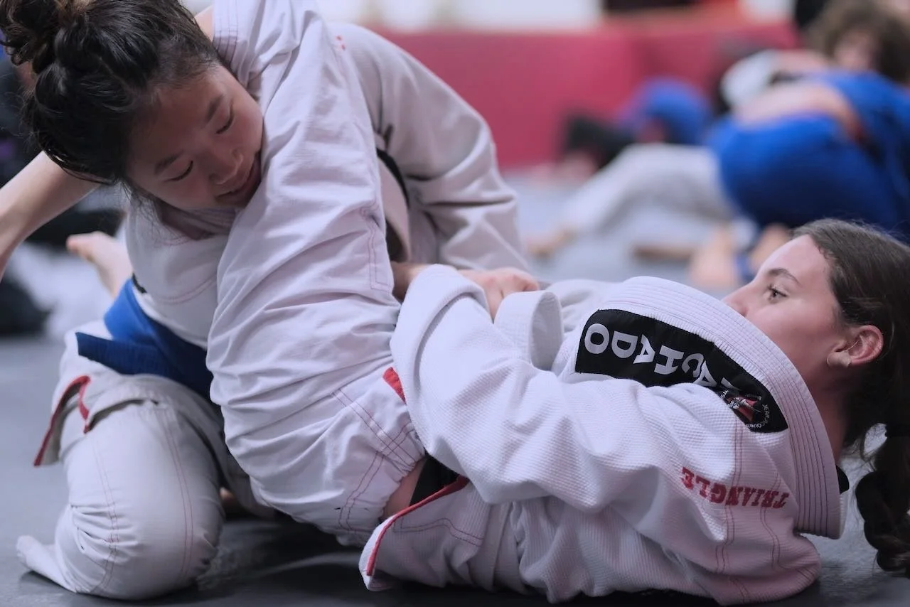 Two Budo Scholar students grappling in a Brazilian Jiu-Jitsu class