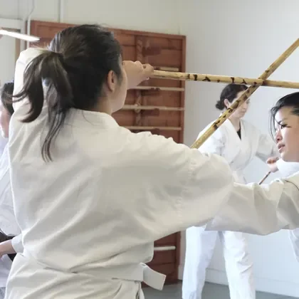 Students practising paired weapons forms with wooden staffs