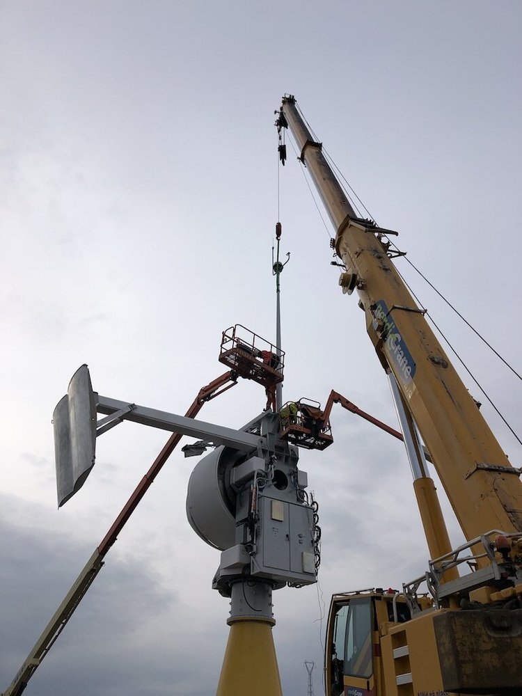 Crane installing a tower head at a test site