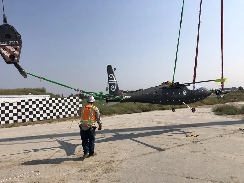 eVTOL aircraft rigged between two cranes for a full-scale passenger survivability crash test