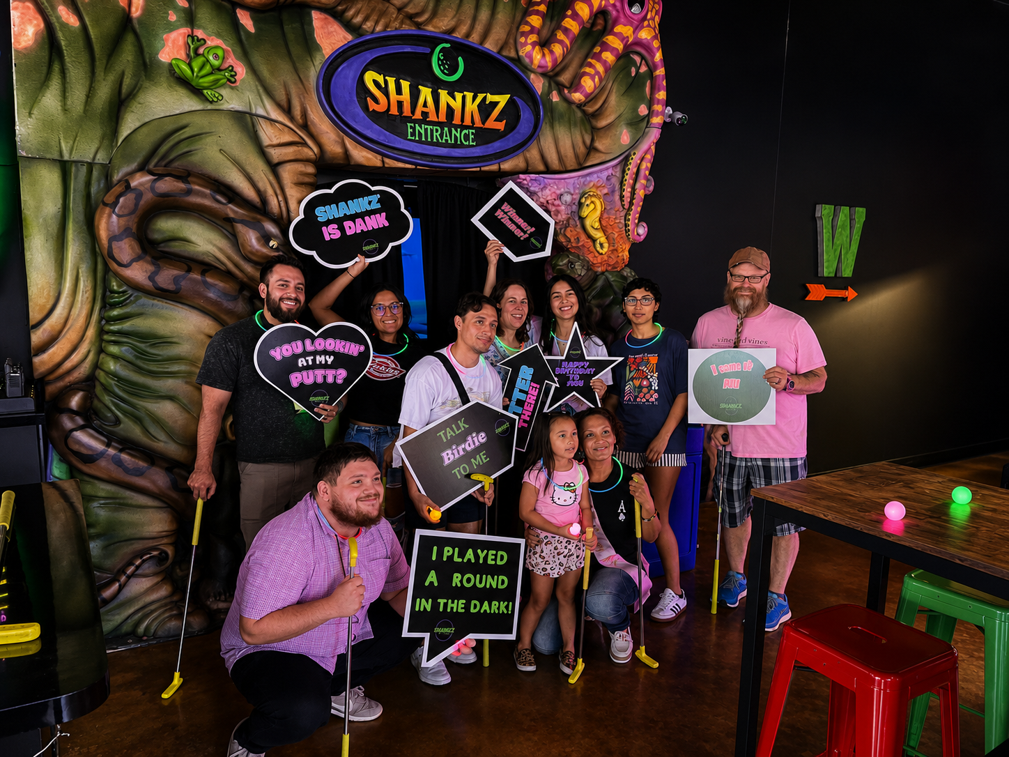 Group celebrating a birthday party at Shankz with glow signs at the entrance
