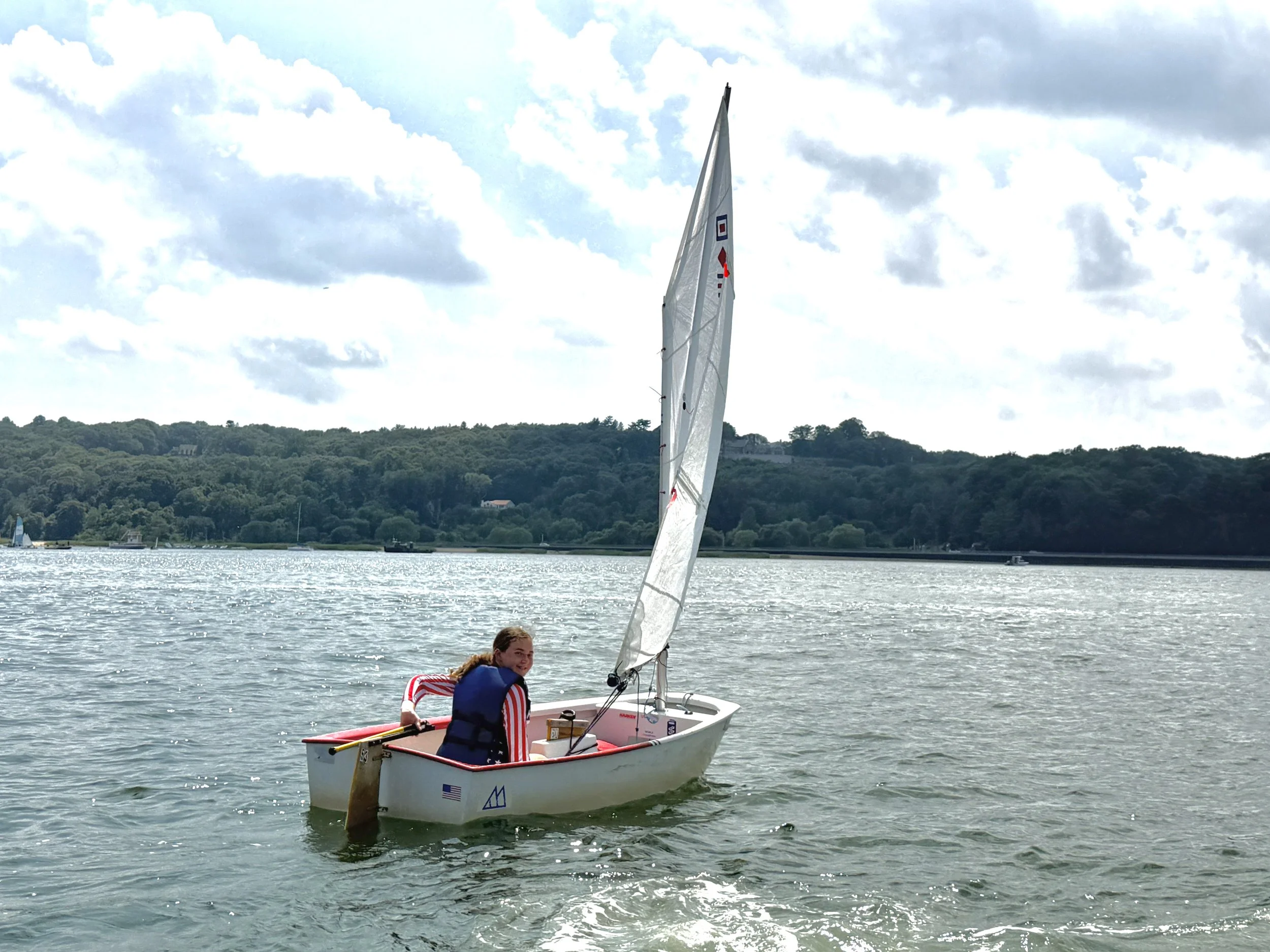 Young sailor in an Optimist dinghy at The WaterFront Center
