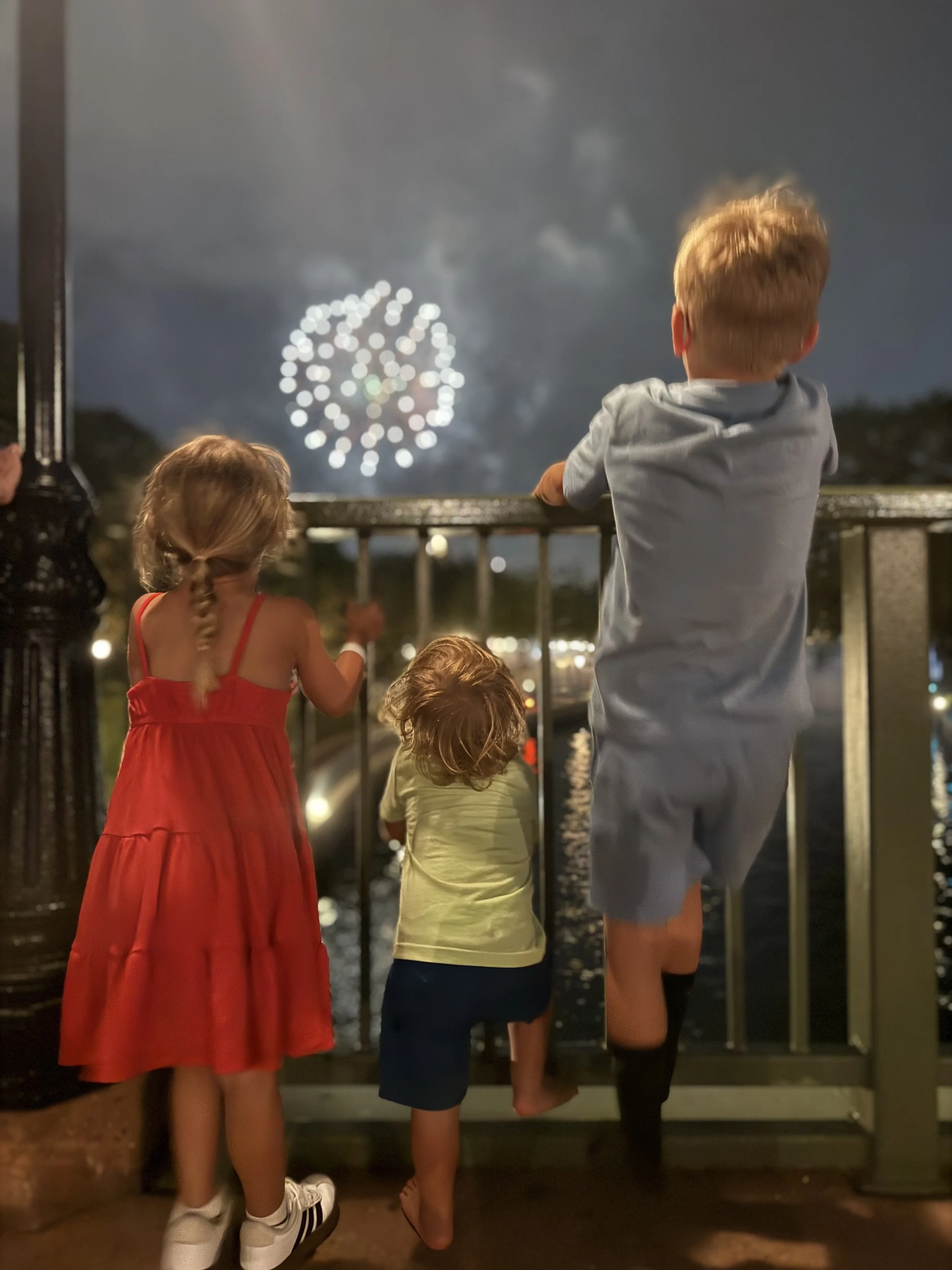 Three kids watching Disney fireworks