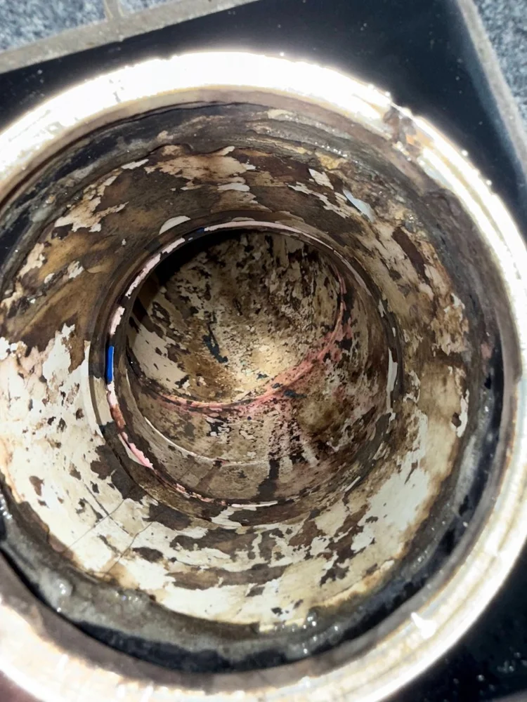 Looking inside a corroded old pipe with scale and rust on the walls