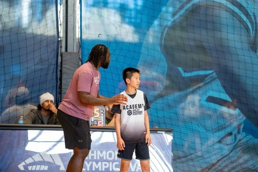 Coach Jeremiah Kabia talking with a young player during a game