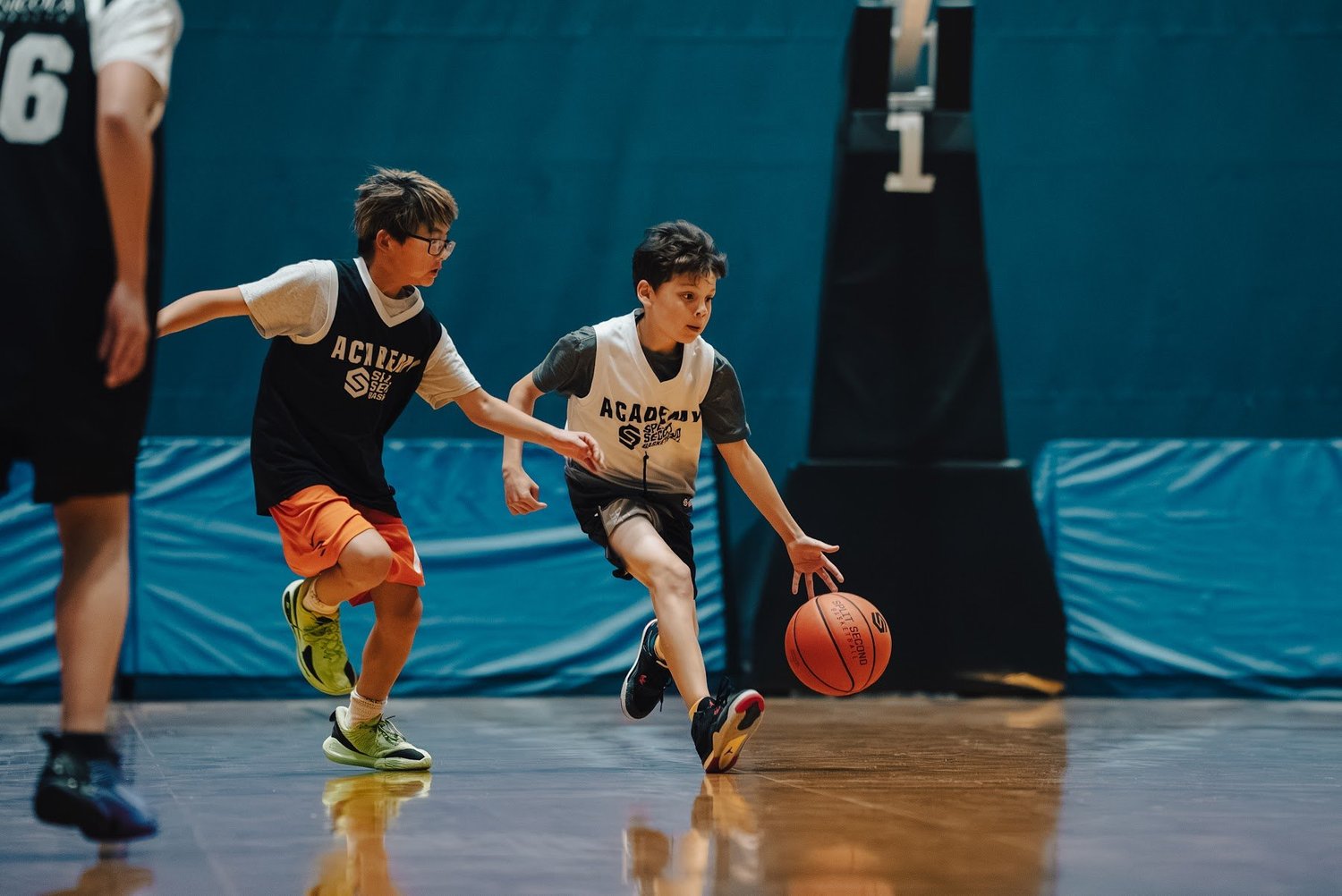 Two Academy players racing up the floor in transition