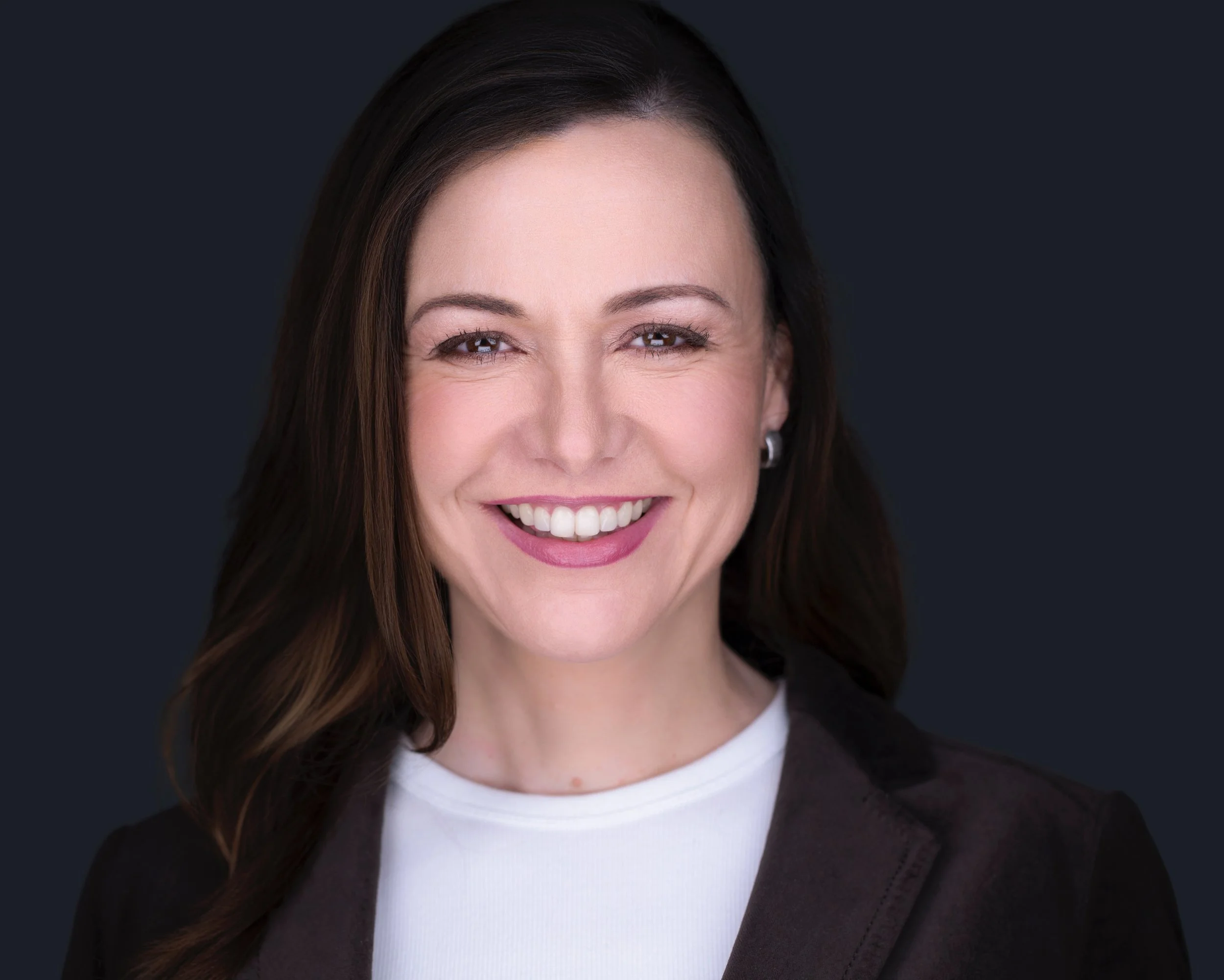 Studio portrait of Laura in a dark jacket and white top, photographed by Nabor Godoy