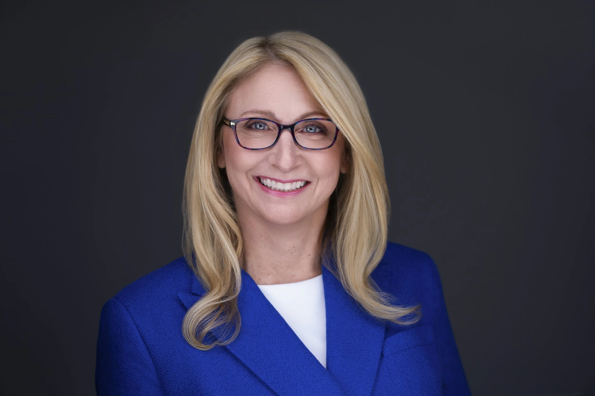 Michelle in a blue jacket, shown in the original horizontal headshot framing