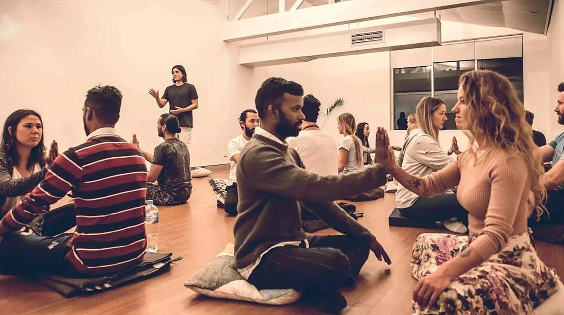 Workshop participants holding palms together while holding eye contact