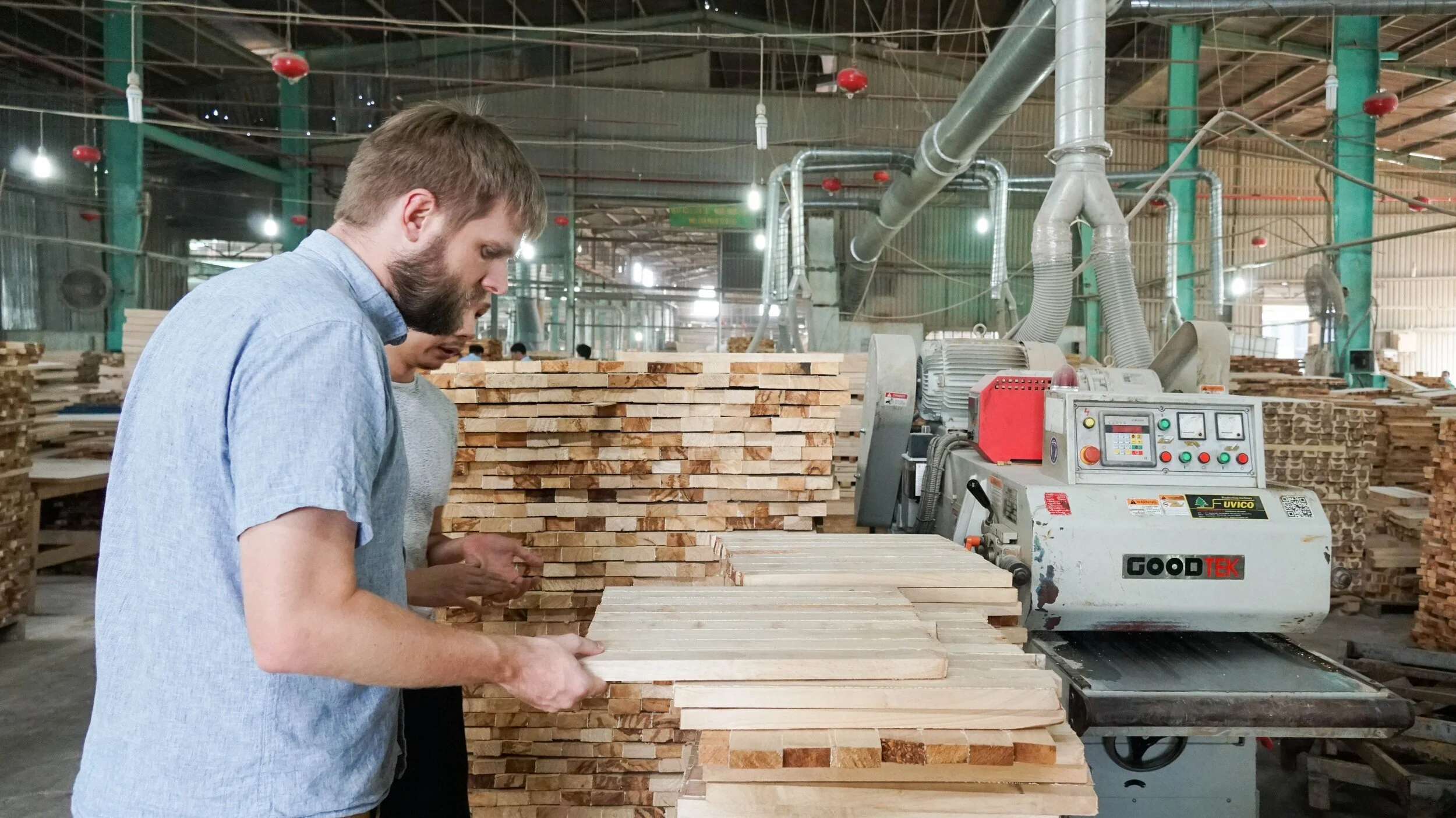 Cosmo Sourcing founder Jim Kennemer inspecting wood at a furniture factory in Vietnam