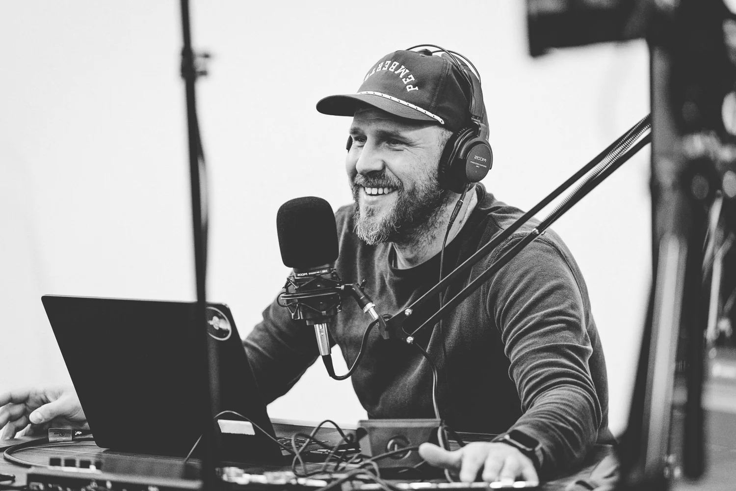 Nick Worpole laughing at the desk while producing a podcast recording, black and white