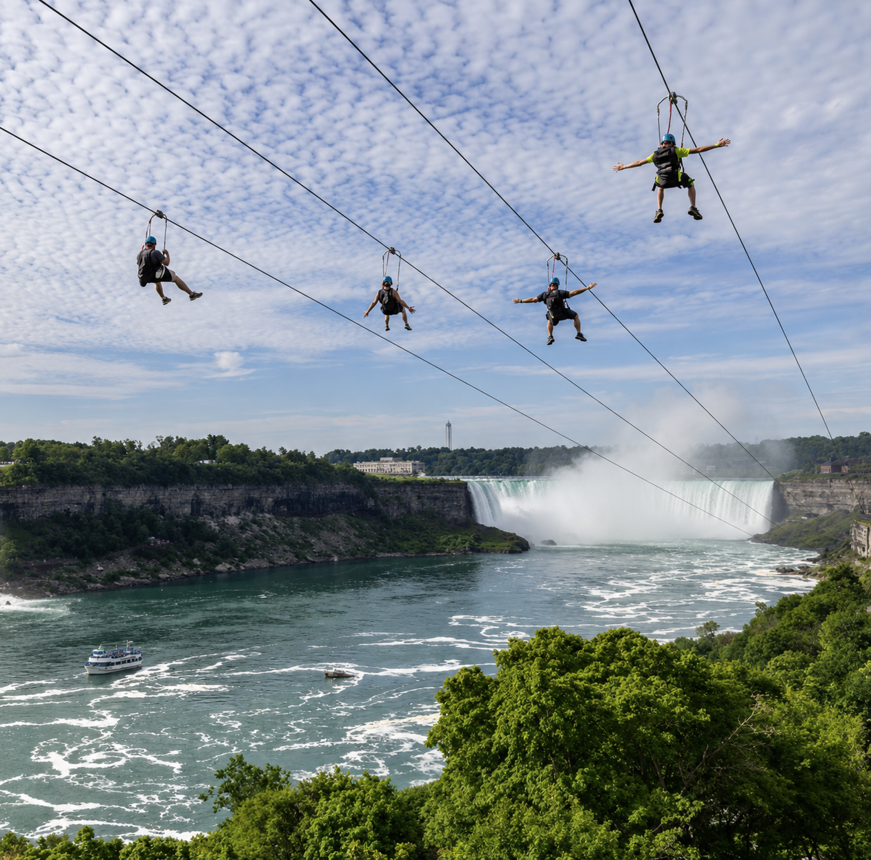Four riders on parallel zip lines descending toward Horseshoe Falls at WildPlay Niagara