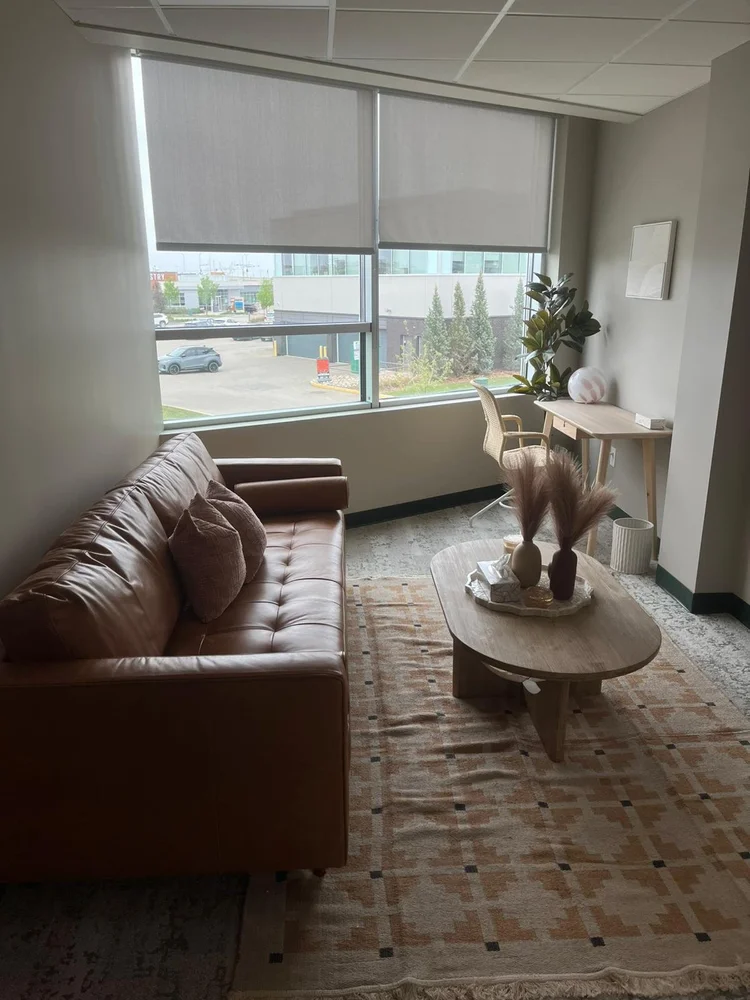 A counselling room at Summit Windermere with a brown velvet sofa and a therapy dog resting on it