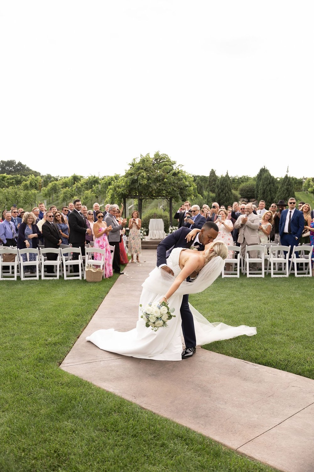 Groom dipping the bride at the end of the aisle