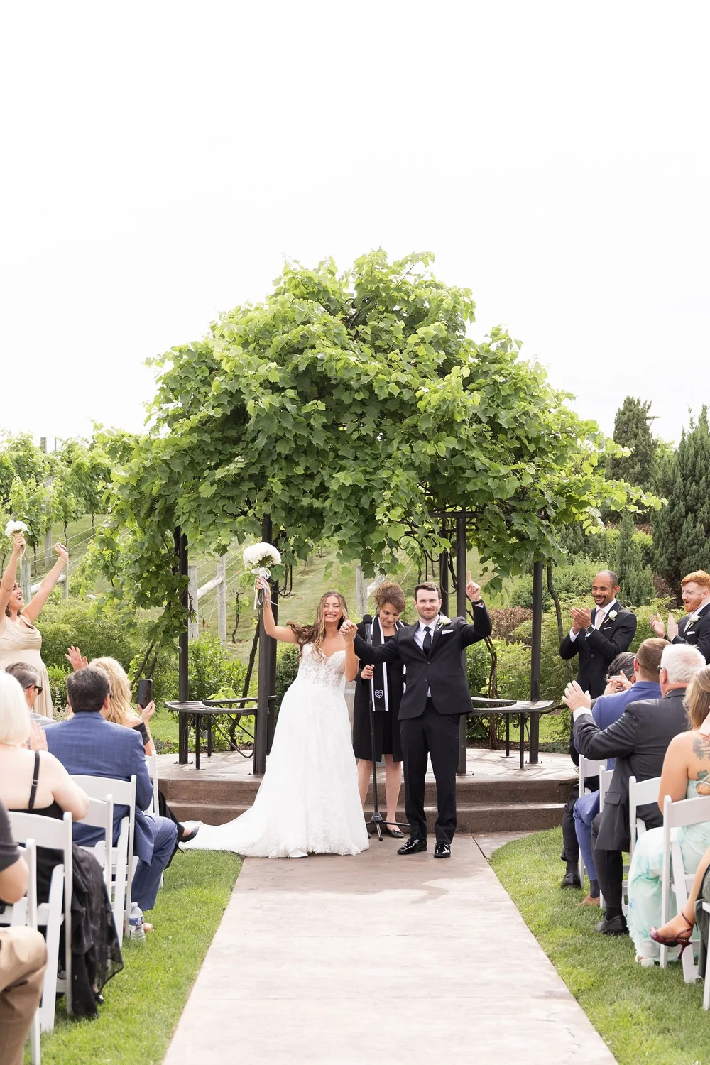 Couple celebrating at the end of the aisle at the gazebo
