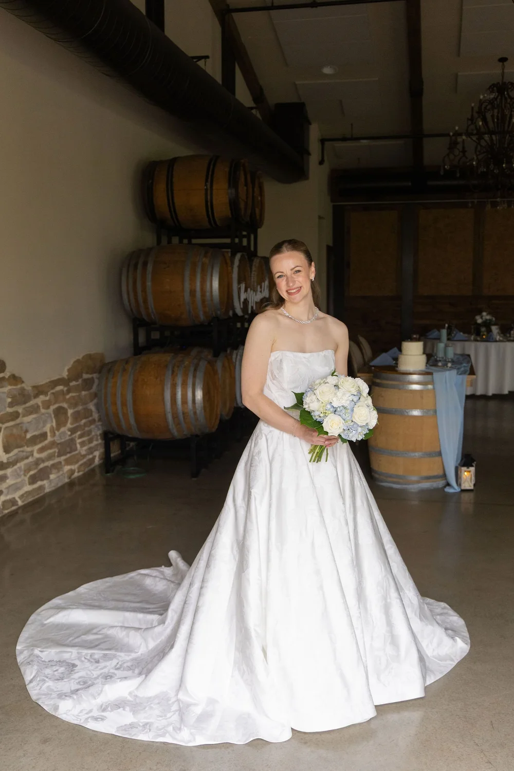Bride in the Barrel Room at Folino Estate surrounded by wine barrels