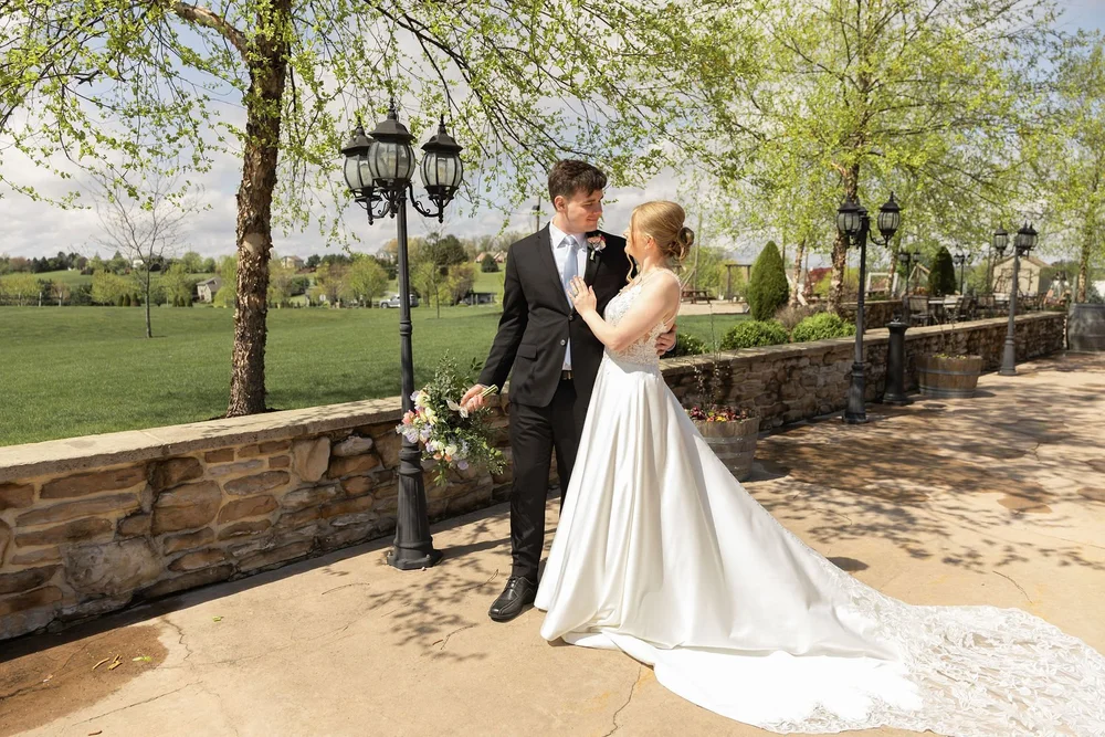 Couple beside a lamp post with the vineyard behind them