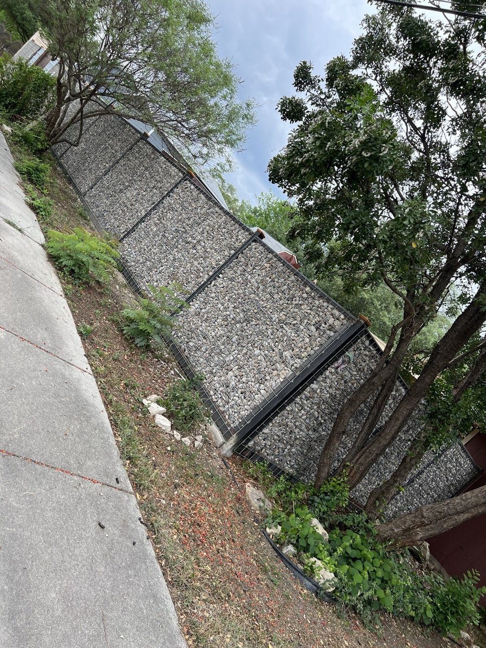 Six-foot welded gabion fence filled with river rock along the San Antonio property