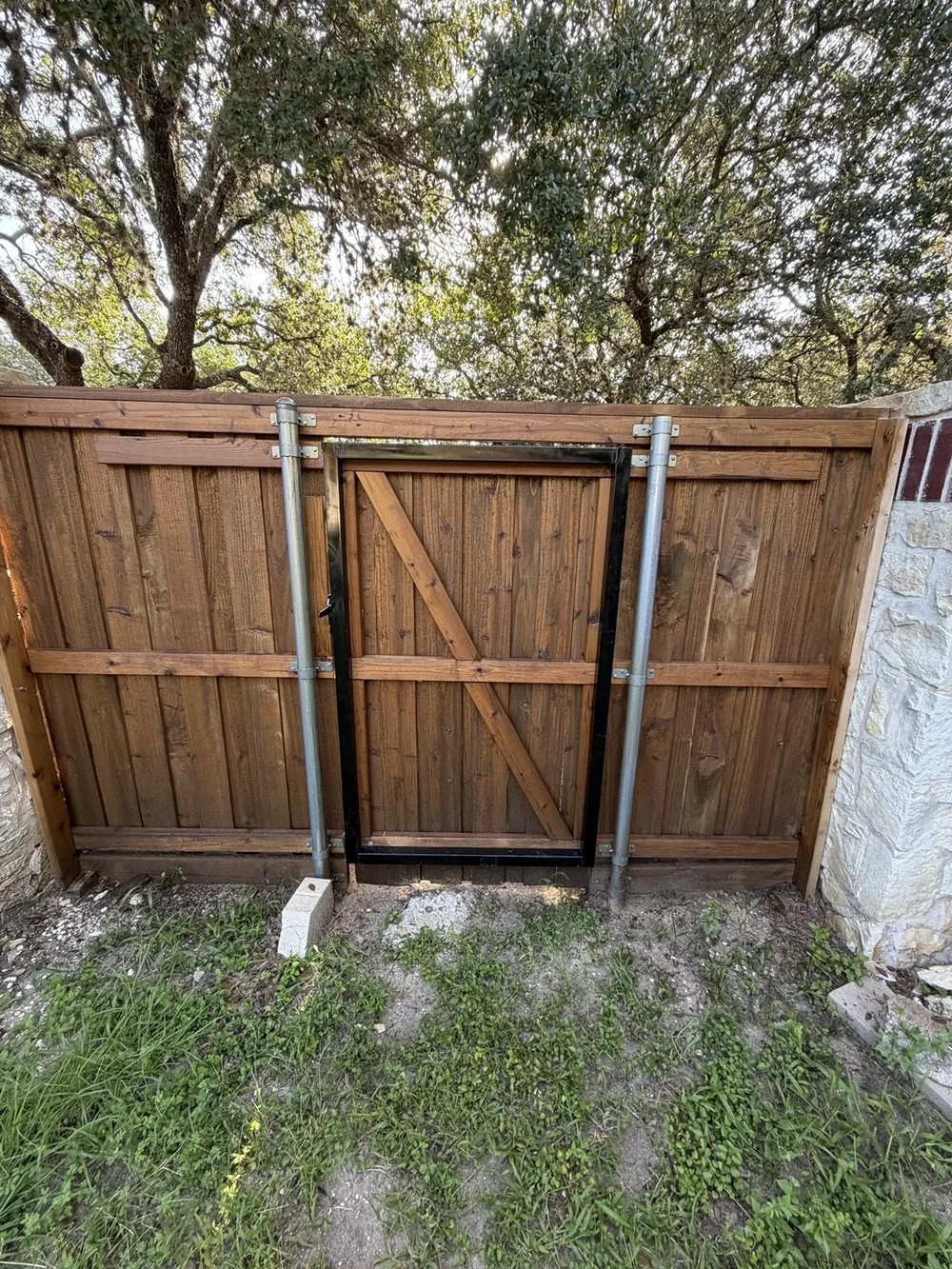 Rear view of Boerne pedestrian gate with wood framing and metal fence posts