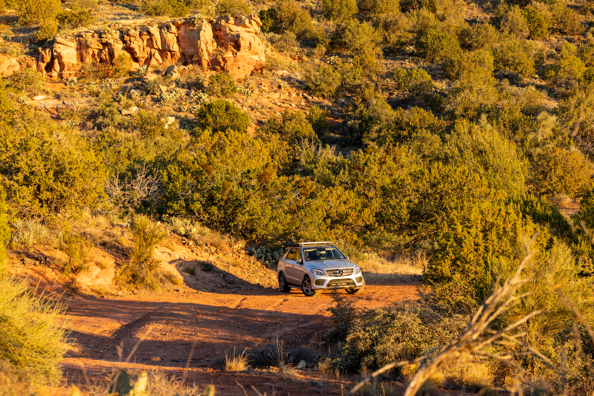 Mercedes GLE on red dirt road with mountains