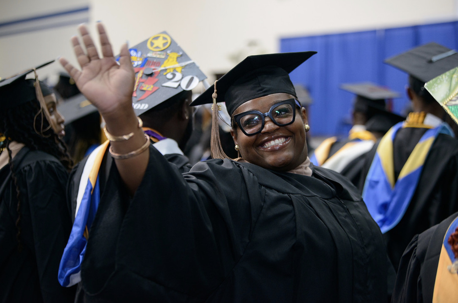 An Allen graduate waving to family at Commencement