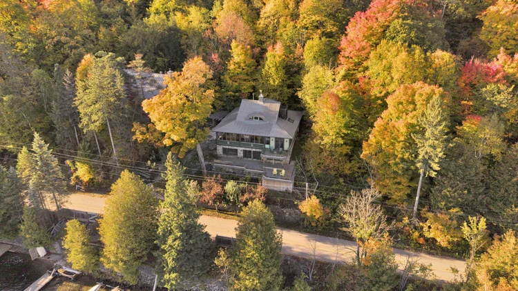Aerial view of the waterfront home and wooded grounds at 755 Ch. du Lac-Meech, Chelsea