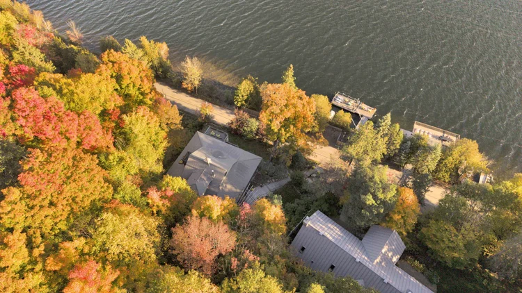 Aerial view of the waterfront home and wooded grounds at 755 Ch. du Lac-Meech, Chelsea