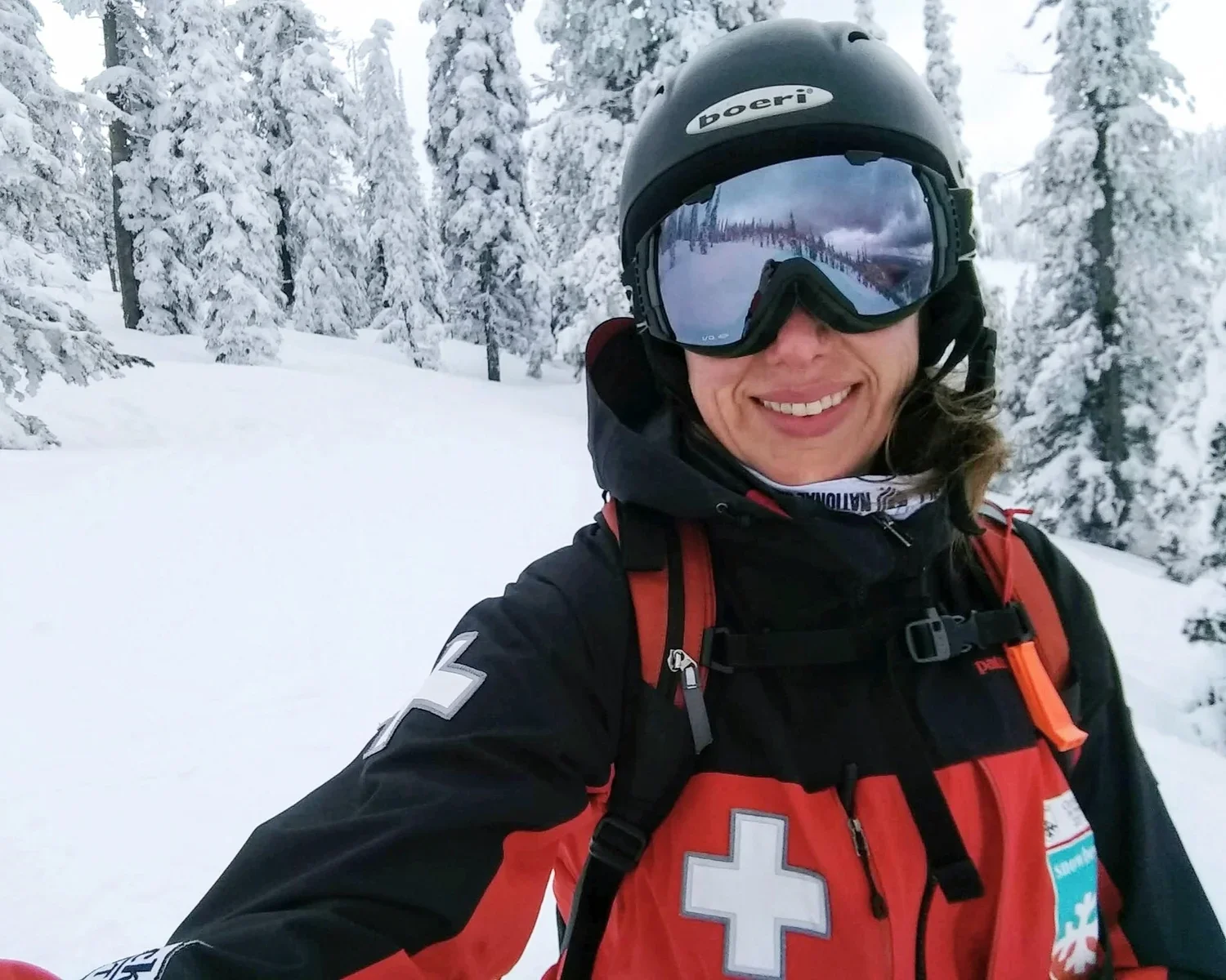Christine Lustik in red ski patrol uniform at Montana Snowbowl