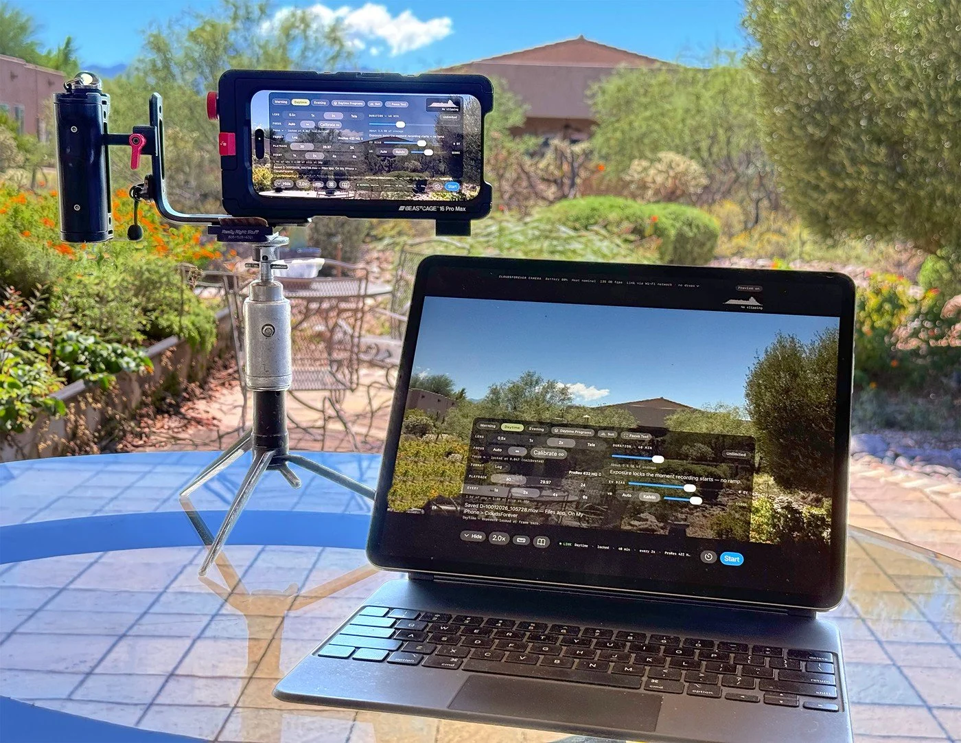 The camera phone in its cage on a small tripod, and an iPad on a patio table showing the camera's live view and its control panel