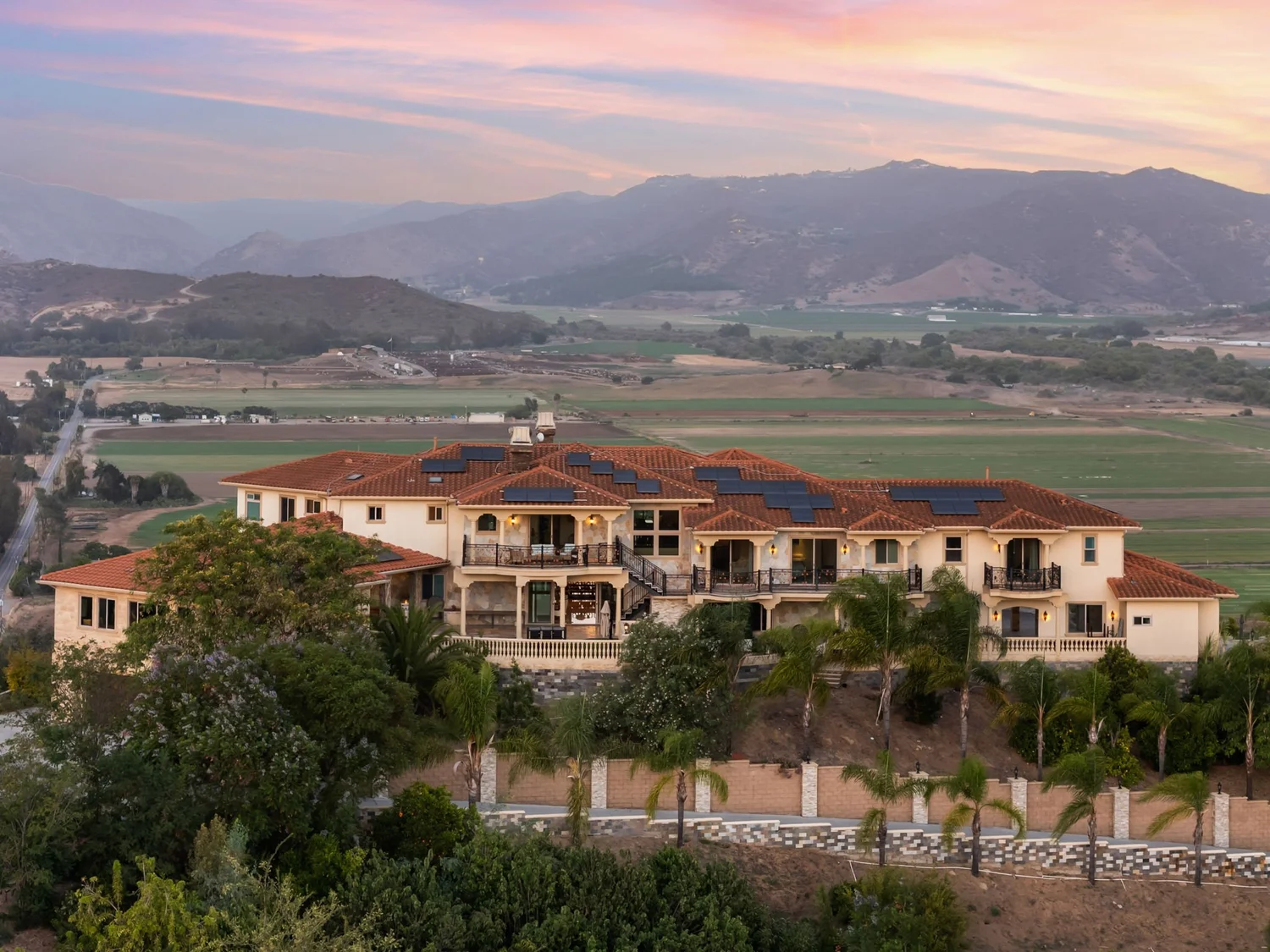 Mediterranean-style hillside estate at dusk overlooking a valley