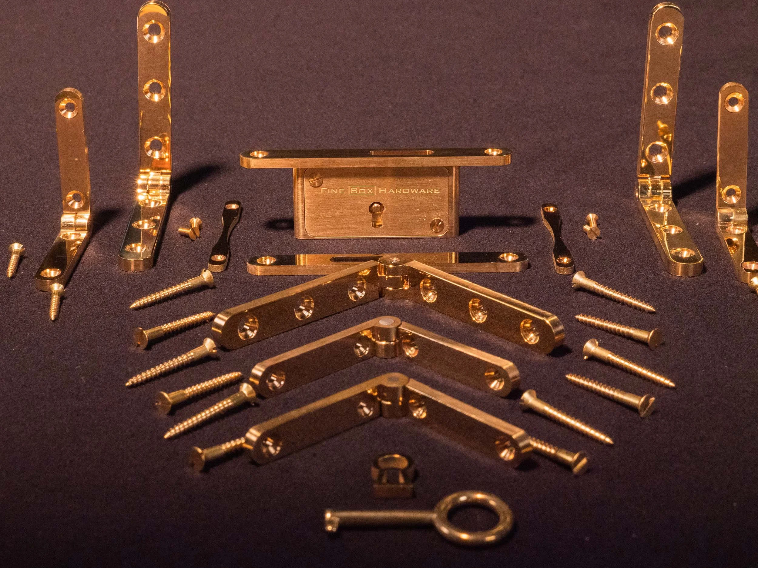 Solid brass precision hardware set: lock, hinges, escutcheons, key, and tray handles