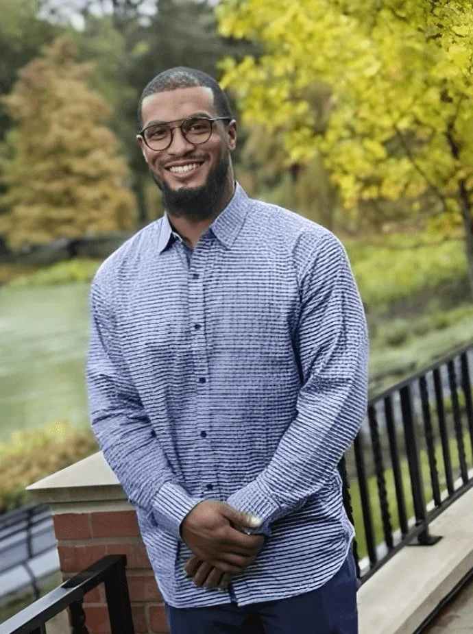 man with glasses and business shirt smiling to camera