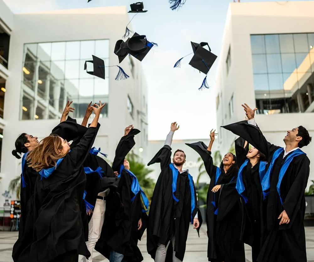 ICSW graduates throwing their caps at commencement